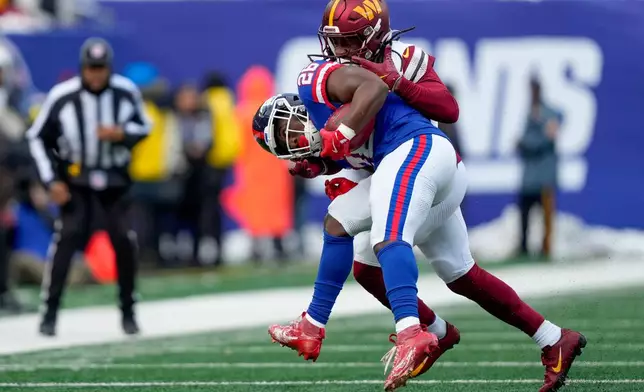 New York Giants running back Devin Singletary (26) is tackled by Washington Commanders outside linebacker Von Miller (24) during the second quarter of an NFL football game, Sunday, Dec. 14, 2025, in East Rutherford, N.J. (AP Photo/Yuki Iwamura)