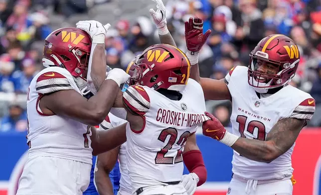 Washington Commanders running back Jacory Croskey-Merritt (22) celebrates with teammates after scoring a touchdown against the New York Giants during the second quarter of an NFL football game, Sunday, Dec. 14, 2025, in East Rutherford, N.J. (AP Photo/Yuki Iwamura)