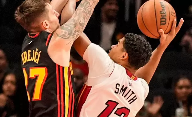 Miami Heat guard Dru Smith (12) shoots against Atlanta Hawks guard Vit Krejci (27) during the first half of an NBA basketball game, Friday, Dec. 26, 2025, in Atlanta. (AP Photo/Mike Stewart)