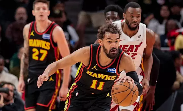 Atlanta Hawks guard Trae Young (11) drives against the Miami Heat during the first half of an NBA basketball game, Friday, Dec. 26, 2025, in Atlanta. (AP Photo/Mike Stewart)