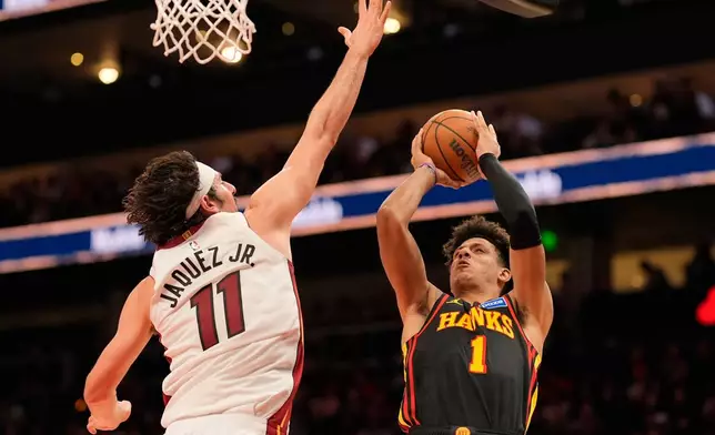 Atlanta Hawks forward Jalen Johnson (1) shoots against Miami Heat forward Jaime Jaquez Jr. (11) during the first half of an NBA basketball game, Friday, Dec. 26, 2025, in Atlanta. (AP Photo/Mike Stewart)