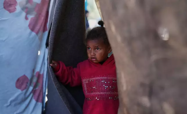 2-year-old Sidra Obeid looks on as she stands in her family's tent in a makeshift camp for displaced Palestinians in Deir al-Balah, central Gaza Strip, Saturday, Dec. 27, 2025. (AP Photo/Abdel Kareem Hana)
