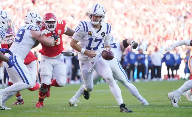 FILE - Indianapolis Colts quarterback Daniel Jones, wearing a special pad on his lower left leg, reaches back to hand off the ball during an NFL football game against the Kansas City Chiefs, Sunday, Nov. 23, 2025, in Kansas City, Mo. (AP Photo/Ed Zurga, File)