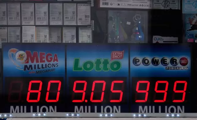 Jackpot payouts for the Mega Millions, Lotto, and Powerball are seen in a convenience store window in Prospect Height, Ill., Monday, Dec. 15, 2025. (AP Photo/Nam Y. Huh)