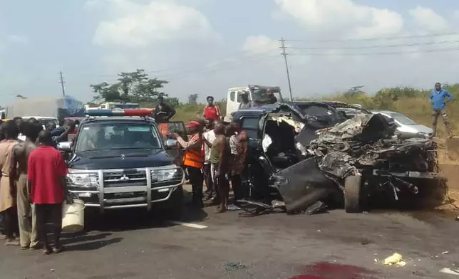 In this photo provided by the Federal Road Safety Corps, people gather at the accident scene of British boxer Anthony Joshua in Lagos, Nigeria, on Monday, Dec. 29, 2025. (Federal Road Safety Corps via AP)