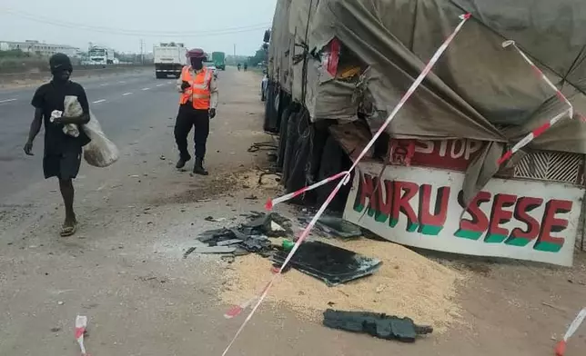 In this photo provided by the Federal Road Safety Corps, people walk past the accident scene of British boxer Anthony Joshua in Lagos, Nigeria, on Monday, Dec. 29, 2025. (Federal Road Safety Corps via AP)