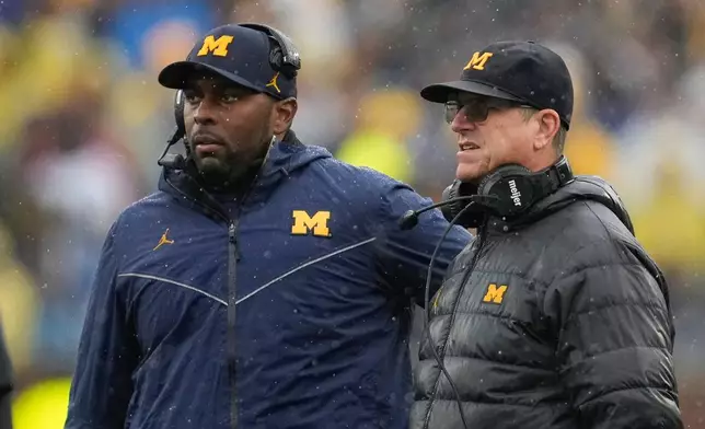 FILE - Michigan offensive coordinator Sherrone Moore, left, and coach Jim Harbaugh watch the team's play against Indiana during an NCAA college football game in Ann Arbor, Mich., Oct. 14, 2023. (AP Photo/Paul Sancya)