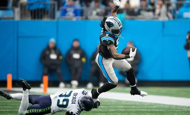 Carolina Panthers running back Rico Dowdle is tackled by Seattle Seahawks safety Ty Okada during the first half of an NFL football game, Sunday, Dec. 28, 2025, in Charlotte, N.C. (AP Photo/Jacob Kupferman)