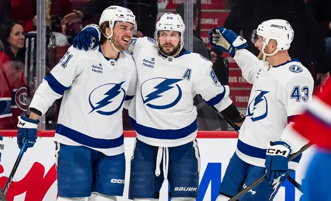 Tampa Bay Lightning' Charle-Edouard D'Astous (51) celebrates his goal with teammates Nikita Kucherov (86) and Darren Raddysh (43) during second period NHL hockey action against the Montreal Canadiens in Montreal on Tuesday, Dec. 9, 2025. (Christopher Katsarov/The Canadian Press via AP)