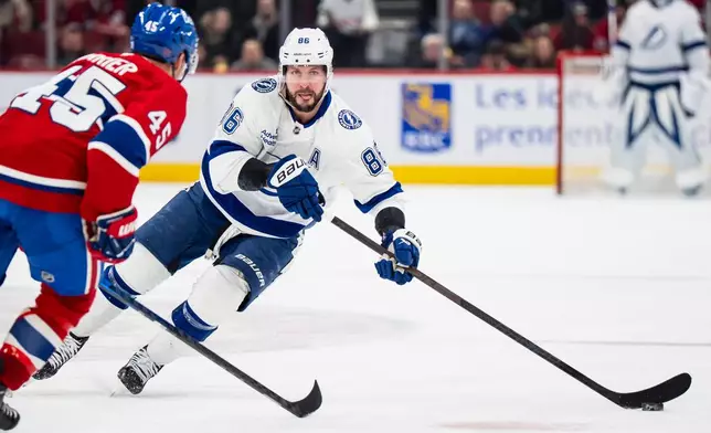 Tampa Bay Lightning' Nikita Kucherov (86) skates with the puck while Montreal Canadiens' Alexandre Carrier (45) defends during the second period of an NHL hockey game, in Montreal, Tuesday, Dec. 9, 2025. (Christopher Katsarov/The Canadian Press via AP)
