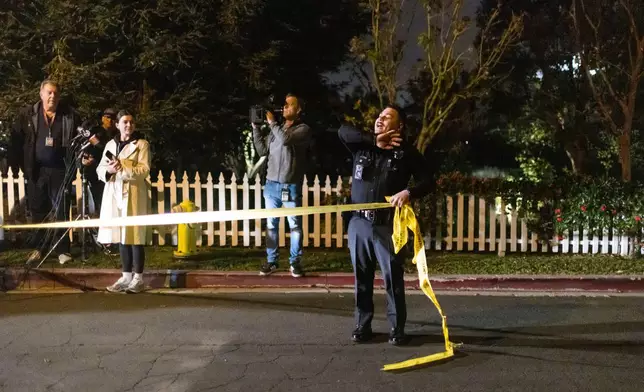 A police officer blocks off a street near Rob Reiner's residence Sunday, Dec. 14, 2025, in the Brentwood section of Los Angeles. (AP Photo/Ethan Swope)