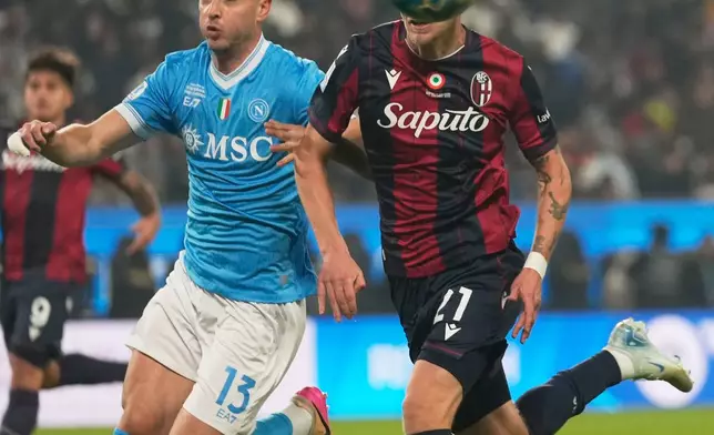 Bologna's Jens Odgaard, right, and Napoli's Amir Rrahmani vie for the ball during the Italian Super Cup final soccer match between Napoli and Bologna in Riyadh, Saudi Arabia, Monday, Dec. 22, 2025. (AP Photo/Altaf Qadri)