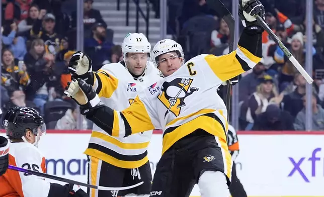 Pittsburgh Penguins' Sidney Crosby (87) and Bryan Rust (17) celebrate after a goal by Crosby during the first period of an NHL hockey game against the Philadelphia Flyers Monday, Dec. 1, 2025, in Philadelphia. (AP Photo/Matt Slocum)