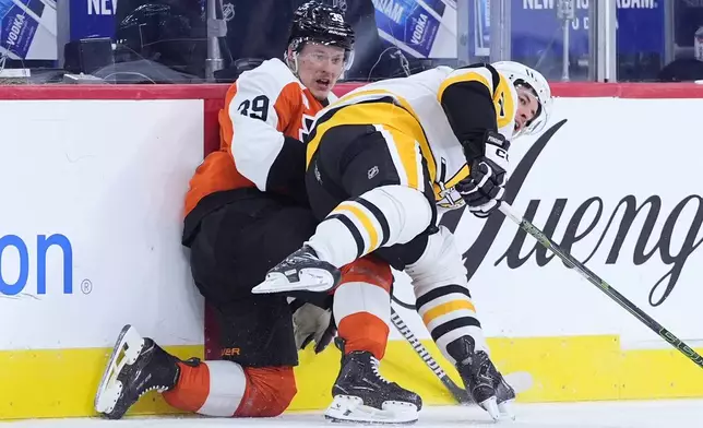 Pittsburgh Penguins' Sidney Crosby, right, collides with Philadelphia Flyers' Matvei Michkov during the second period of an NHL hockey game Monday, Dec. 1, 2025, in Philadelphia. (AP Photo/Matt Slocum)