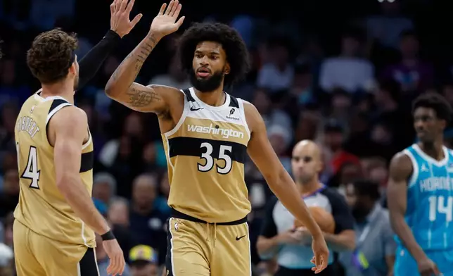 Washington Wizards forward Marvin Bagley III (35) high-fives forward Corey Kispert after scoring against the Charlotte Hornets during the first half of an NBA basketball game in Charlotte, N.C., Tuesday, Dec. 23, 2025. (AP Photo/Nell Redmond)