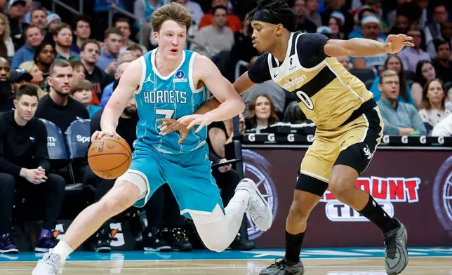Charlotte Hornets guard Kon Knueppel, left, drives against Washington Wizards guard Bilal Coulibaly (0) during the first half of an NBA basketball game in Charlotte, N.C., Tuesday, Dec. 23, 2025. (AP Photo/Nell Redmond)