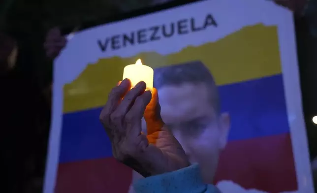 A Venezuelan opposition member holds up a candle during a demonstration ahead of the Nobel Peace Prize ceremony where Venezuelan Maria Corina Machado is among this year's laureates, in Mexico City, Saturday, Dec. 6, 2025. (AP Photo/Marco Ugarte)