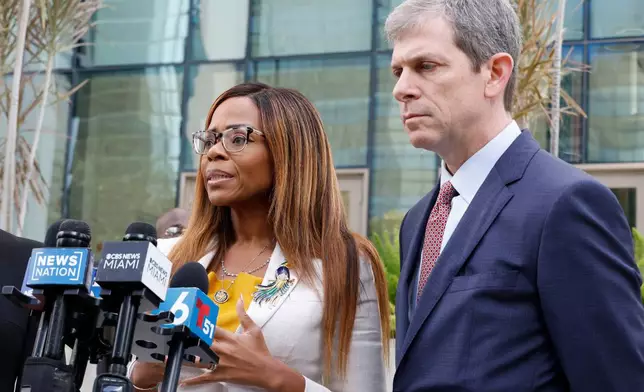 CORRECTS TO HEARING, NOT ARRAIGNMENT - U.S. Rep. Sheila Cherfilus-McCormick, D-Fla., left, speaks to the media as her lawyer David Markus looks on after a hearing in federal court Monday, Dec. 29, 2025 in Miami. (AP Photo/Terry Renna)