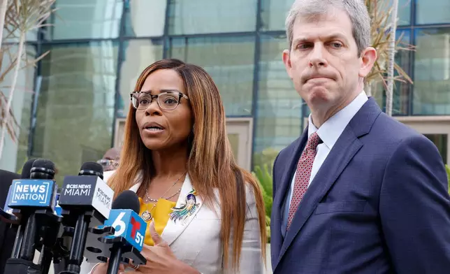 CORRECTS TO HEARING, NOT ARRAIGNMENT - U.S. Rep. Sheila Cherfilus-McCormick, D-Fla., left, speaks to the media as her lawyer David Markus looks on after a hearing in federal court Monday, Dec. 29, 2025 in Miami. (AP Photo/Terry Renna)