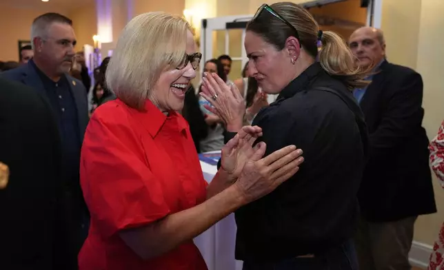 Miami mayor-elect Eileen Higgins, left, celebrates with a supporter at a watch party after winning the Miami mayoral runoff election, Tuesday, Dec. 9, 2025, in Miami. (AP Photo/Lynne Sladky)
