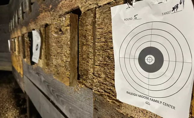 A fresh paper target hangs beside a pellet-shredded wooden wall during a turkey shoot at Moose Lodge 1318 in Wake Forest, N.C., on Friday, Dec. 12, 2025. (AP Photo/Allen G. Breed)
