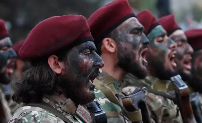 Fighters from the new Syrian army chant as they march during celebrations marking the first anniversary of the ousting of former President Bashar Assad in Damascus, Syria, Monday, Dec. 8, 2025. (AP Photo/Omar Sanadiki)