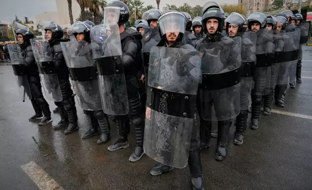 Riot police stand in formation ahead of a parade by the new Syrian army marking the first anniversary of the ousting of the Bashar Assad regime in Damascus, Syria, early Monday, Dec. 8, 2025. (AP Photo/Hussein Malla)