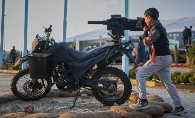 A boy handles a weapon at the "Syrian Revolution Military Exhibition," which opened last week ahead of the first anniversary of the ousting of the Bashar Assad regime in Damascus, Syria, Sunday, Dec. 7, 2025. (AP Photo/Ghaith Alsayed)