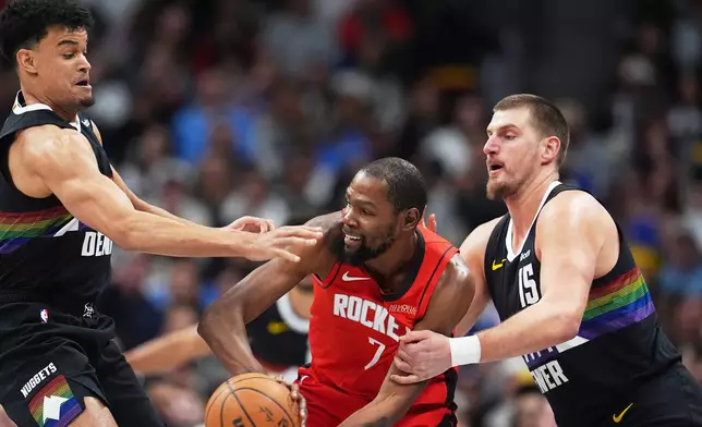 Houston Rockets forward Kevin Durant, center, look to pass the ball as Denver Nuggets forward Spencer Jones and center Nikola Jokić defend in the first half of an NBA basketball game Saturday, Dec. 20, 2025, in Denver. (AP Photo/David Zalubowski)