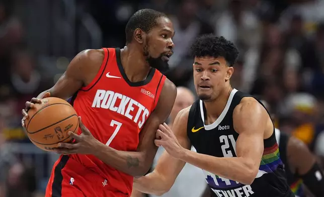 Houston Rockets forward Kevin Durant, left, looks to pass the ball as Denver Nuggets forward Spencer Jones defends in the first half of an NBA basketball game Saturday, Dec. 20, 2025, in Denver. (AP Photo/David Zalubowski)