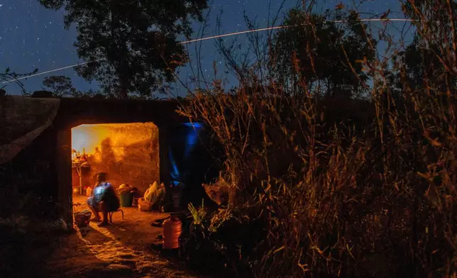 Thai resident cooks in a shelter while Thai military fires artillery towards Cambodia, Saturday, Dec. 20, 2025, in Surin province, Thailand. (AP Photo/Wason Wanichakorn)