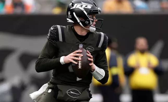 New York Jets quarterback Brady Cook (4) looks to pass against the Miami Dolphins during the second quarter of an NFL football game, Sunday, Dec. 7, 2025, in East Rutherford, N.J. (AP Photo/Adam Hunger)