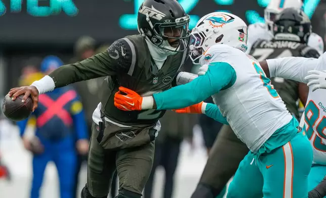 New York Jets quarterback Tyrod Taylor (2) avoids a sack by DUPLICATE***Miami Dolphins outside linebacker Matthew Judon (8) during the first quarter of an NFL football game, Sunday, Dec. 7, 2025, in East Rutherford, N.J. (AP Photo/Yuki Iwamura)