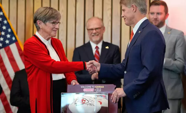 Kansas City Chiefs owner Clark Hunt, right, and Kansas Gov. Laura Kelly, shake hands during an event announcing the team will leave Arrowhead Stadium in Kansas City, Mo. for a new stadium that will be built across the Kansas-Missouri state line and be ready for the start of the 2031 season, during an event Monday, Dec. 22, 2025 in Topeka, Kan. (AP Photo/Charlie Riedel)