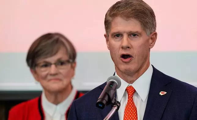 Kansas City Chiefs owner Clark Hunt, right, addresses attendees while Kansas Gov. Laura Kelly, left, looks on during an event Monday, Dec. 22, 2025, in Topeka, Kan., announcing the team will leave Arrowhead Stadium in Kansas City, Mo. for a new stadium that will be built across the Kansas-Missouri state line and be ready for the start of the 2031 season. (AP Photo/Charlie Riedel)