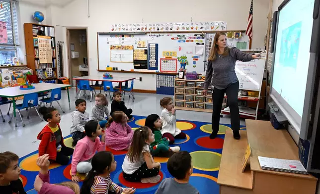 Kindergarten teacher Christin Labriola points out Hawaii on a map, incorporating Asian American and Pacific Islander subjects in her class at Webster Hill Elementary School in West Hartford, Conn., on Dec. 2, 2025. (AP Photo/Jessica Hill)