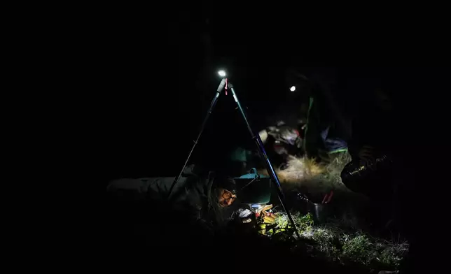 Marco Calo, a geophysicist at the National Autonomous University of Mexico (UNAM), prepares food at the campsite on the slopes of the Popocatepetl volcano, Mexico, Thursday, Dec. 4, 2025. (AP Photo/Eduardo Verdugo)