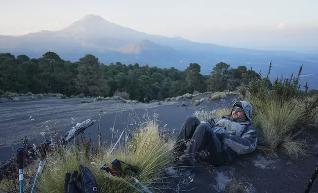 Marco Calo, a geophysicist at the National Autonomous University of Mexico (UNAM), rests near the campsite on the slopes of the Popocatepetl volcano, Mexico, Thursday, Dec. 4, 2025. (AP Photo/Eduardo Verdugo)