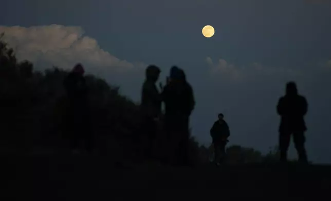 Students observe the moon near the campsite on the slopes of the Popocatepetl volcano, Mexico, Thursday, Dec. 4, 2025. (AP Photo/Eduardo Verdugo)