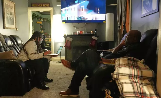 Ahmad Collins, watches television along with his wife Nickey Collins at their home in Harrisburg, Pa., Thursday, Dec. 11, 2025. A city government worker and former Penn State linebacker, Collins has needed 10 hours a night of dialysis since a medical procedure left him with damaged kidneys late last year. (AP Photo/Matt Rourke)