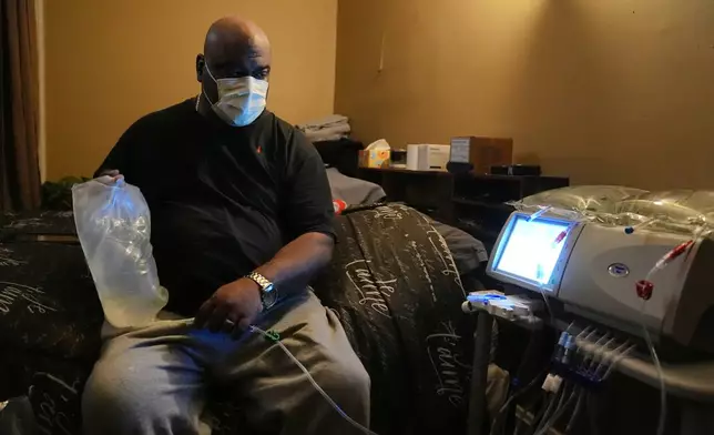 Ahmad Collins, a city government worker and former Penn State linebacker, prepares for his nightly dialysis at his home in Harrisburg, Pa., Thursday, Dec. 11, 2025. (AP Photo/Matt Rourke)
