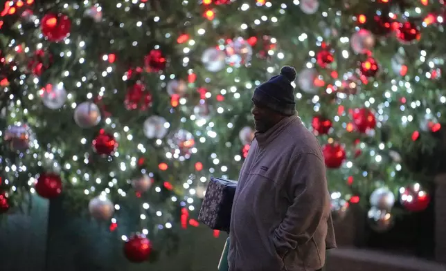 Ahmad Collins heads for his office in Harrisburg, Pa., Thursday, Dec. 11, 2025. A city government worker and former Penn State linebacker, Collins has needed 10 hours a night of dialysis since a medical procedure left him with damaged kidneys late last year. (AP Photo/Matt Rourke)