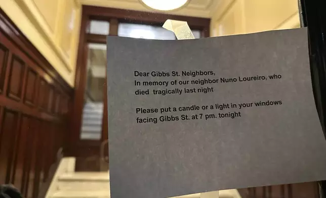 A notice encouraging neighbors of Massachusetts Institute of Technology professor Nuno F.G. Loureiro to display candles in their windows to honor his life is taped to an apartment door in Brookline, Mass., Tuesday, Dec. 16, 2025. (AP Photo/Leah Willingham)
