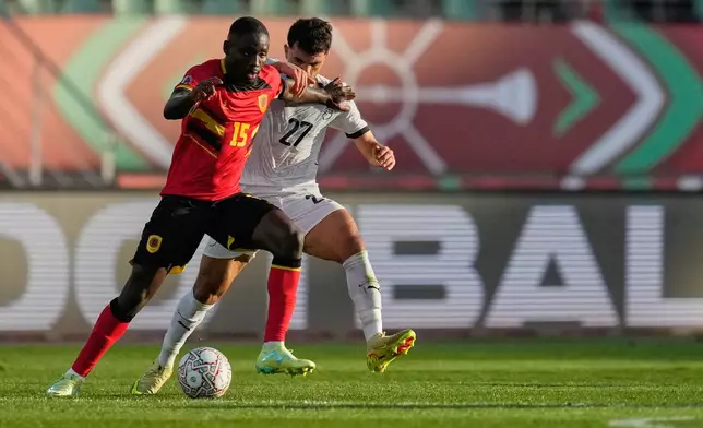 Angola's Beni Mukendi and Egypt's Mahmoud Saber compete for the ball during the Africa Cup of Nations group B soccer match between Angola and Egypt in Agadir, Morocco, Monday, Dec. 29, 2025. (AP Photo/Mosa'ab Elshamy)