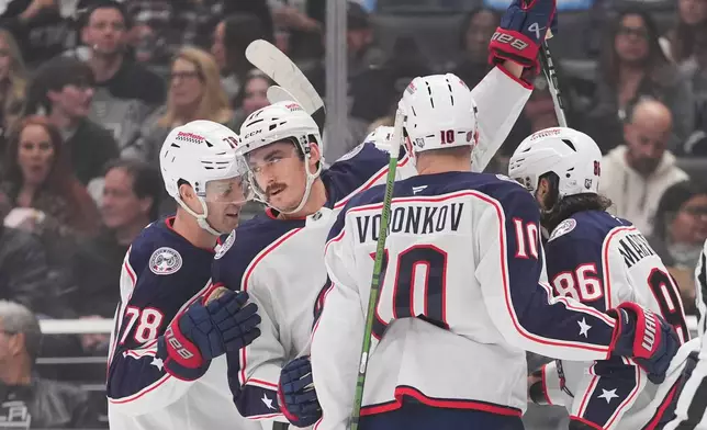 Columbus Blue Jackets's Mason Marchment (17) celebrates his goal with Damon Severson (78), Dmitri Voronkov (10) and Kirill Marchenko (86) during the first period of an NHL hockey game against the Los Angeles Kings Monday, Dec. 22, 2025, in Los Angeles. (AP Photo/Jae C. Hong)
