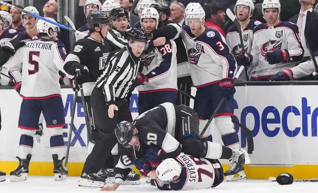 Columbus Blue Jackets defenseman Damon Severson (78) is pinned to the ice by Los Angeles Kings right wing Corey Perry (10) during the second period of an NHL hockey game Monday, Dec. 22, 2025, in Los Angeles. (AP Photo/Jae C. Hong)