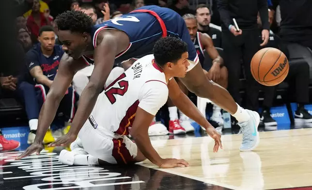 Miami Heat guard Dru Smith (12) is fouled by Los Angeles Clippers guard Kobe Brown during the first half of an NBA basketball game, Monday, Dec. 1, 2025, in Miami. (AP Photo/Lynne Sladky)