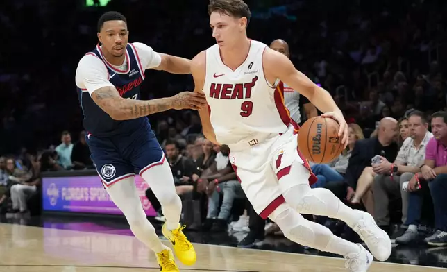 Miami Heat guard Pelle Larsson (9) drives to the basket as Los Angeles Clippers guard Jordan Miller, left, defends during the first half of an NBA basketball game, Monday, Dec. 1, 2025, in Miami. (AP Photo/Lynne Sladky)