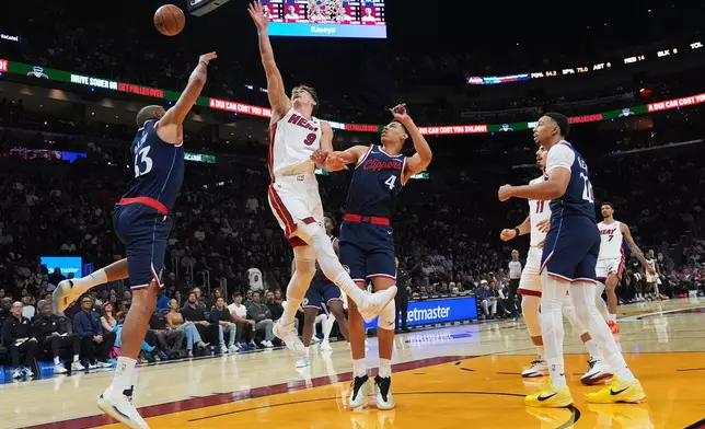 Miami Heat guard Pelle Larsson (9) goes to the basket as Los Angeles Clippers forward Nicolas Batum (33) defends during the first half of an NBA basketball game, Monday, Dec. 1, 2025, in Miami. (AP Photo/Lynne Sladky)