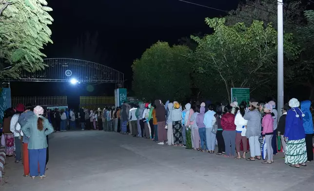 Voters wait for a polling station to open in Naypyitaw, Myanmar, Sunday, Dec. 28, 2025. (AP Photo/Aung Shine Oo)